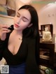 A woman in a black top smoking a cigarette.