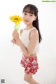 A young girl holding a sunflower in her hand.