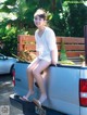 A woman sitting on the back of a pickup truck.