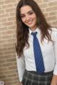 A young woman in a school uniform posing for a picture.